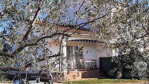 Une maison avec un toit en tuiles, un balcon et une clôture.
