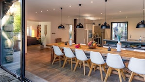 A modern kitchen with a wooden island, white chairs, and pendant lighting. - Pet friendly home in Genestelle (Genestelle)
