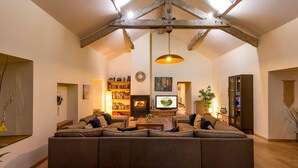 A spacious living room with a large sectional sofa, a fireplace, and a wooden ceiling structure. - Pet friendly home in Genestelle (Genestelle)