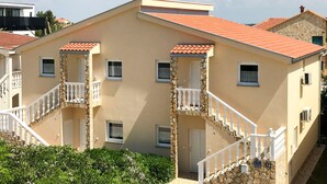 A two-story building with a beige facade, red-tiled roof, and white balconies. - 2 bedroom nice apartment in Vir (Vir)