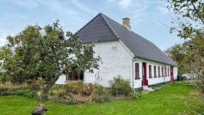A white house with a grey roof, red doors, and a chimney. - 3 bedroom gorgeous home in søby ærø (Søby Ærø)