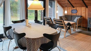A cozy dining area with a round table, black chairs, and a patterned tablecloth. There is a wooden ceiling and a sofa in the background. - Amazing home in Humble with WiFi (Humble)