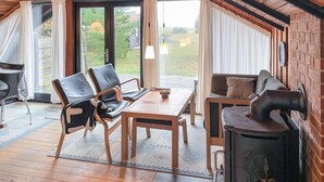 A cozy room with a wooden table, two chairs, a sofa, and a fireplace. - Amazing home in Humble with WiFi (Humble)