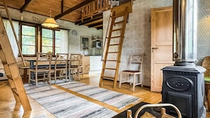 Una cocina rústica con estufa, muebles de madera y una escalera.