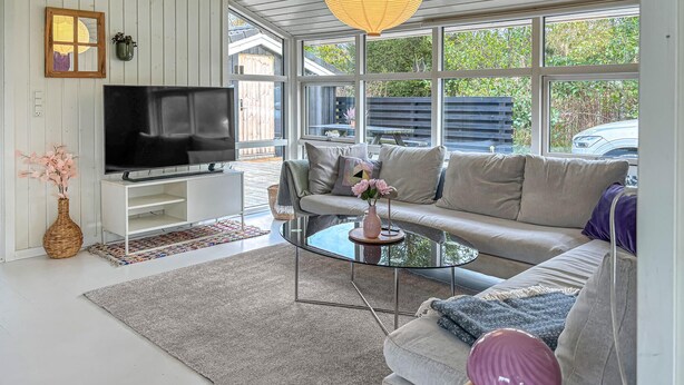 A modern living room with a TV, sofa, coffee table, and a large window. - Lovely home in Fjerritslev with WiFi (Fjerritslev)