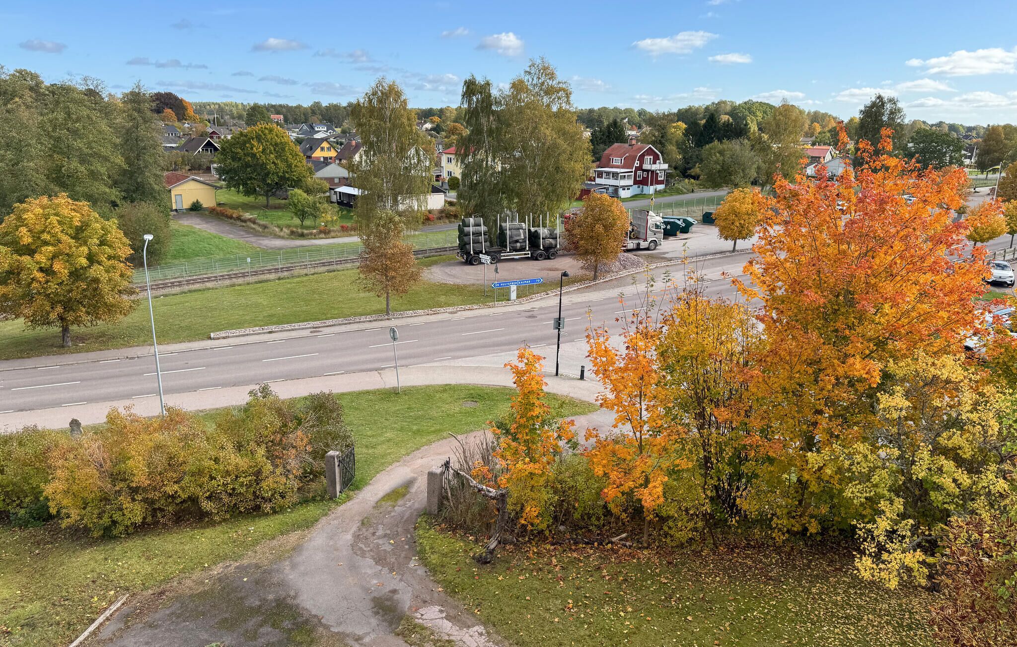 Ein Wohngebiet mit Häusern, einer Straße und Herbstlaub.