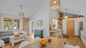 Ein geräumiger Wohnbereich mit Sofa, Esstisch und Küche.