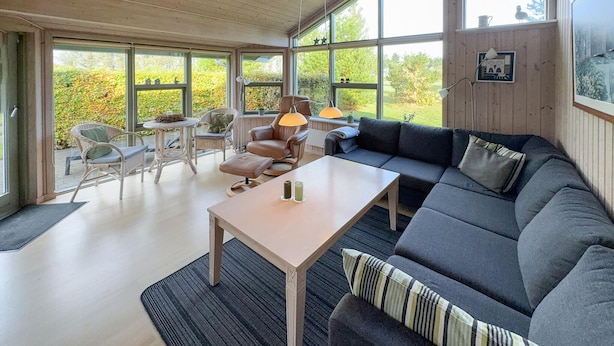 A spacious living area with a large window, a sofa, a table, and two chairs. - 3 bedroom awesome home in Tarm (Tarm)