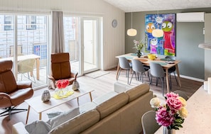A modern living room with a sofa, chairs, a dining table, and a large window. - Amazing apartment in Ringkøbing with WiFi (Ringkøbing)