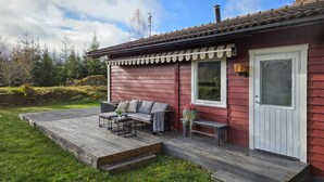 A red wooden house with a covered porch, a white door, and a window. - 1 bedroom awesome home in Boxholm (Boxholm)