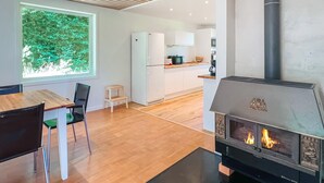 Een moderne keuken met witte kasten, een ingebouwde kookplaat en een raam met uitzicht op groen.