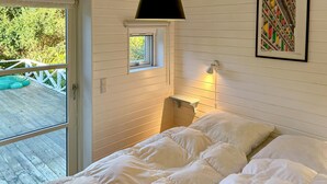 A bedroom with a bed, a window, a small shelf, and a painting on the wall. - Lovely home in Asnæs with WiFi (Asnæs)
