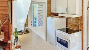 A compact kitchen with white cabinets, a small refrigerator, and an oven. - Lovely home in Asnæs with WiFi (Asnæs)