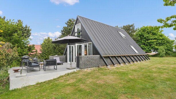 A modern house with a sloped roof, a patio with outdoor furniture, and a large umbrella. - 2 bedroom nice home in Humble (Humble)