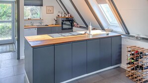 A modern kitchen with a wooden countertop, grey cabinets, a built-in oven, and a wine rack. - 2 bedroom nice home in Humble (Humble)
