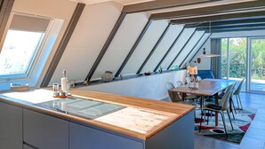 A modern kitchen with a wooden countertop, a dining area with a table and chairs, and a large skylight. - 2 bedroom nice home in Humble (Humble)