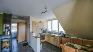 A modern kitchen with a dining area, featuring a stove, microwave, and sink.