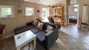 A cozy living room with a dark grey sofa, patterned cushions, a white coffee table, and a wooden cabinet. - Awesome home in Tarm with sauna (Tarm)