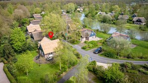 A rural village with traditional thatched-roof houses, a winding road, and a river. - Beautiful home in Paasloo with sauna (Paasloo)
