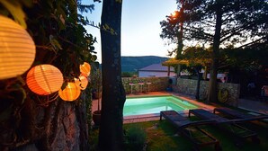 A swimming pool with a stone wall and a grassy area with lounge chairs. - House with heated pool (Bribir)