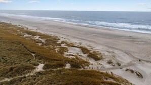 Ein Strand mit freiem Blick auf den Ozean und einem sandigen Weg zum Wasser.