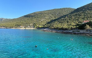 A coastal area with clear turquoise water, a rocky shoreline, and a backdrop of green hills. - 2 bedroom awesome apartment in Gdinj (Gdinj)