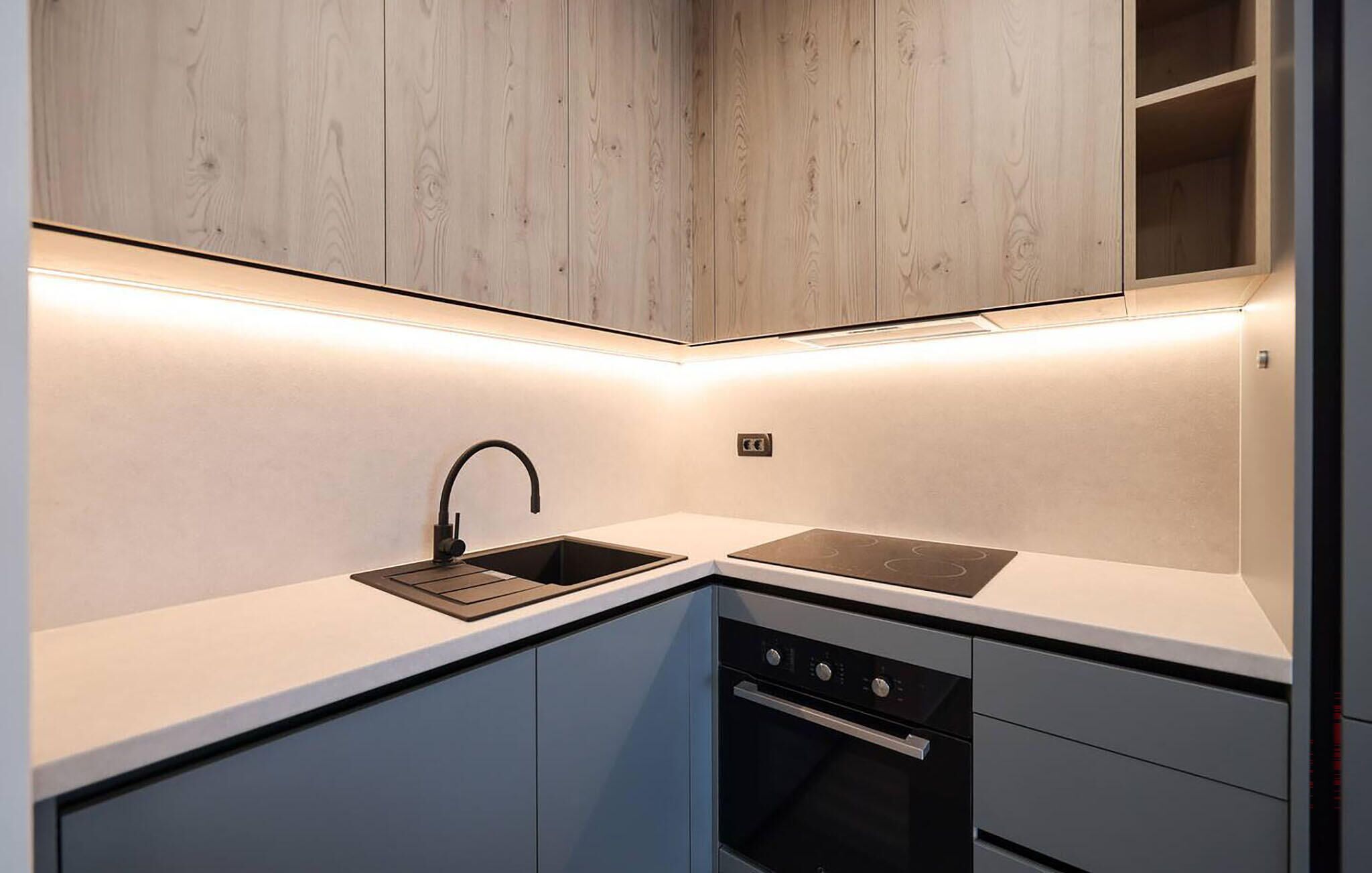 A modern kitchen with a sink, stove, and oven.