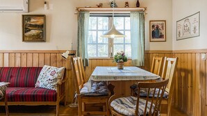 A cozy dining area with a wooden table, chairs, and a red-striped sofa. - 3 bedroom beautiful home in Torsby (Torsby)