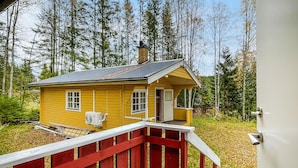 A yellow cabin with a red railing in front, surrounded by trees. - 3 bedroom beautiful home in Torsby (Torsby)