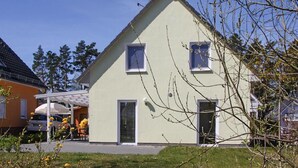 Une maison de plain-pied avec un toit à pignon, deux fenêtres et une porte.
