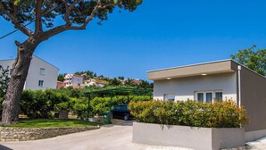 A modern building with a flat roof and large windows, surrounded by greenery and a clear blue sky. - Nice apartment in Podstrana with WiFi (Podstrana)
