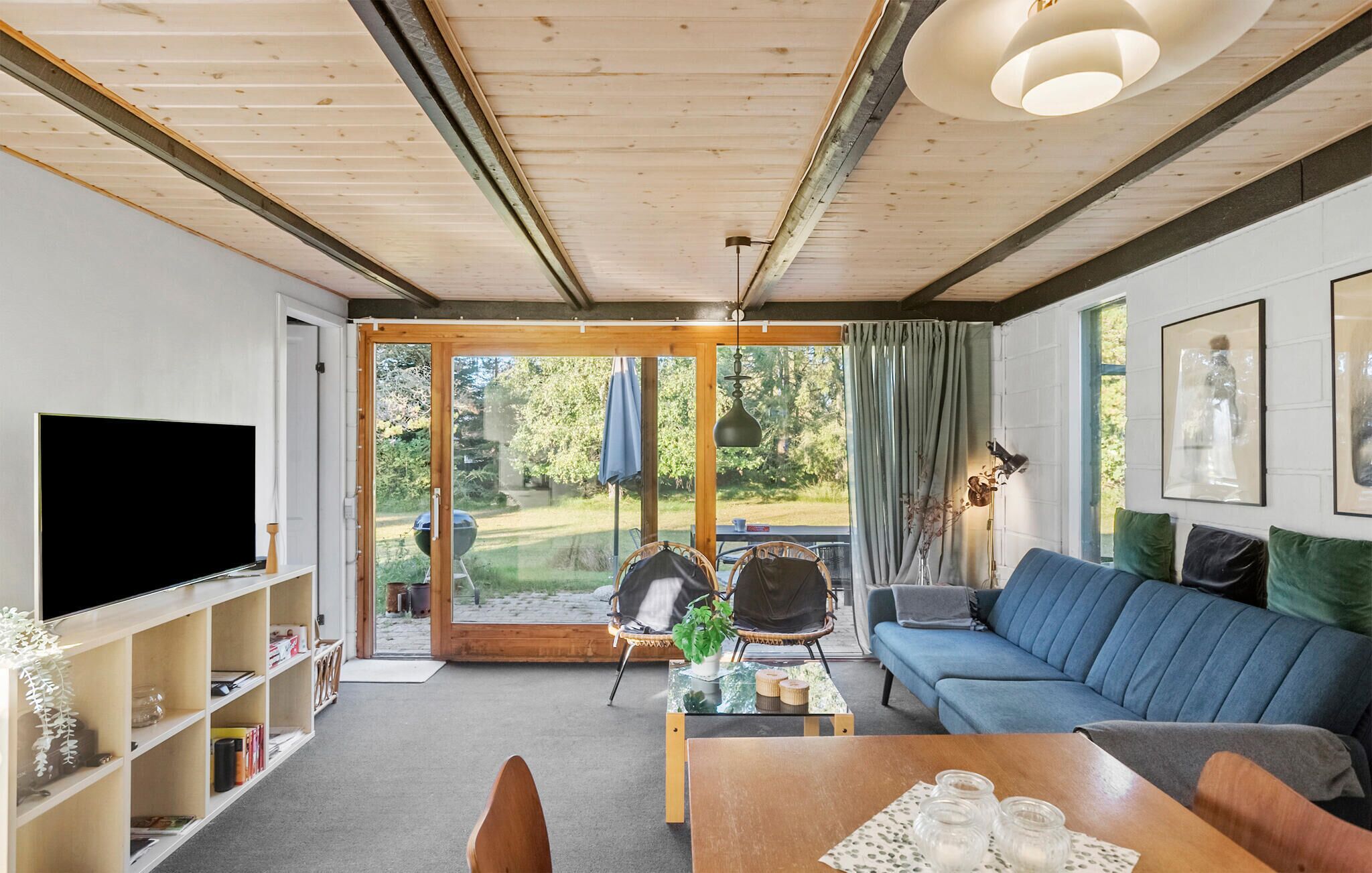 A modern living room with a TV, sofa, and dining table.