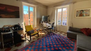 Ein Zimmer mit einem Bett, einem Schreibtisch, einem Sessel und einer Couch.
