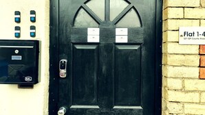 Una porta nera con una finestra, una cassetta postale e un cartello che indica il numero civico da 1 a 4.
