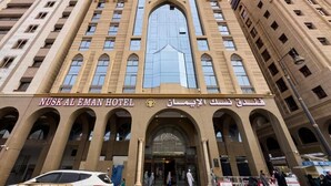 Fachada del Hotel Nusk Al Eman con ventanas de arco y una entrada central.