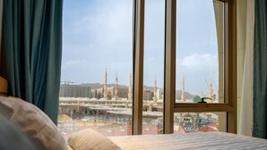 Habitación de hotel con un ventanal que ofrece vistas a una mezquita con minaretes.