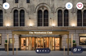 Fasaden på The Manhattan Club är utförd i klassisk sten, har välvda fönster och en väl upplyst entré.