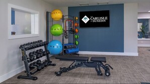 A gym with exercise equipment, a wall-mounted sign, and a window. - Landing | Stylish 2BD, Gym (Dunedin)