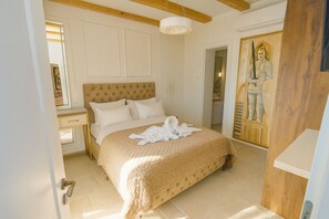 A bedroom with a large bed, a wooden headboard, a painting on the wall, and a wooden door. - Villa D’ Republic Dubrovnik – Infinity Pool & Old Town Views (Dubrovnik)