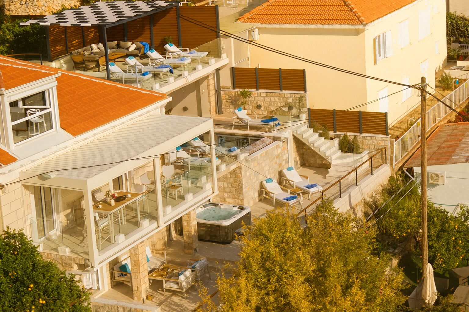 A multi-story building with outdoor seating areas and a hot tub.