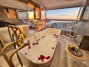 A modern bathroom with a freestanding bathtub, a visible cityscape view, and a glass partition. - Villa D’ Republic Dubrovnik – Infinity Pool & Old Town Views (Dubrovnik)