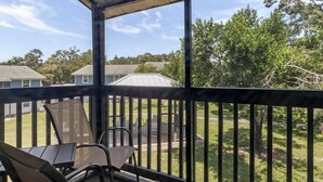 Un espace extérieur abrité offrant une vue sur un quartier résidentiel, avec ses maisons et ses arbres.
