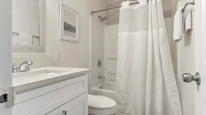 Ein Badezimmer mit Dusche, Toilette und Waschbecken.