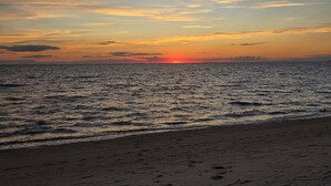 Ein Strand bei Sonnenuntergang über dem Meer.