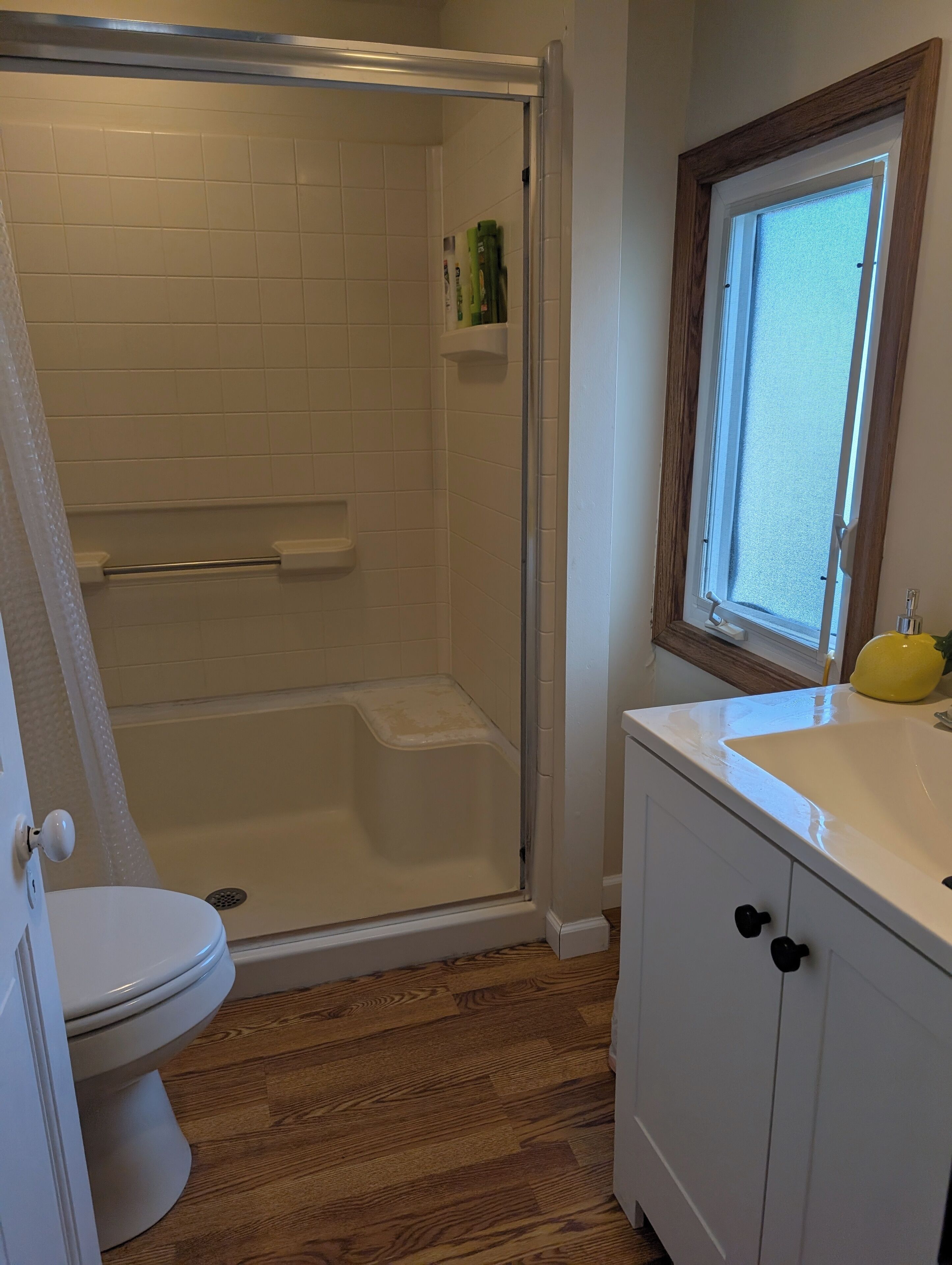 Une salle de bain avec douche, toilettes et lavabo.