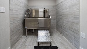 A compact, modern bathroom with a shower enclosure, a stainless steel sink, and a textured floor mat. - Landing | Stylish 1BD, Gym (Dunedin)