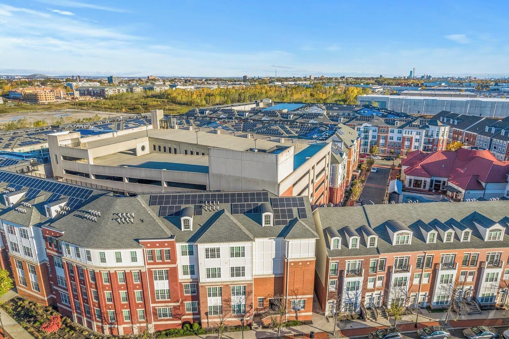A multi-story building with a central courtyard, surrounded by residential buildings with red brick facades and white trim.