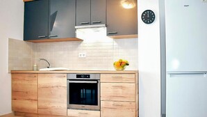 Een moderne keuken met een inbouwoven, een magnetron en een koelkast.