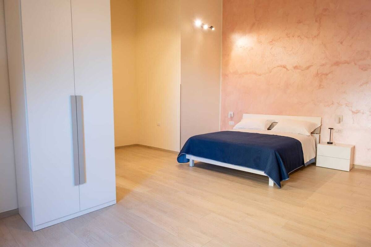 Ein Schlafzimmer mit Bett, Nachttisch und Kleiderschrank.