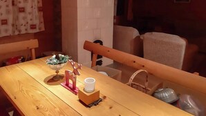 Ein Holztisch mit einer Glaskugel, einem Kerzenhalter und einer Tasse. Ein Korbwesen ist teilweise sichtbar auf der rechten Seite.